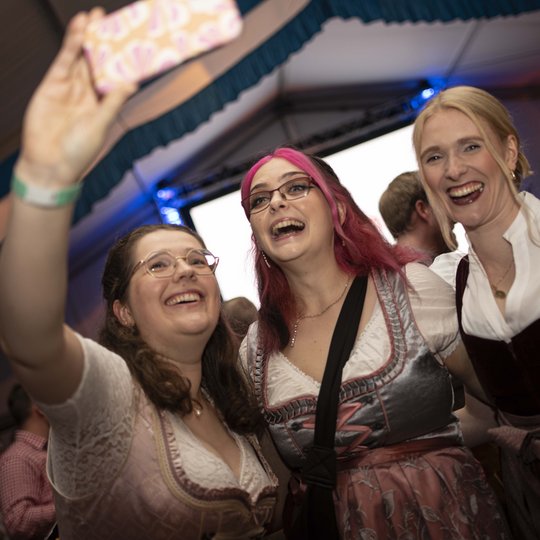 Die Gäste haben viel Spaß auf dem Hollager Oktoberfest. Drei Frauen im Dirndl machen ein Selfie im Festzelt.