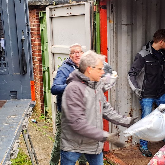 Ehrenamtliche Helfer verladen die gesammelten Altkleider auf einen Lkw. Ehrenamtliche Helfer verladen die gesammelten Altkleider auf einen Lkw.